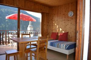 a bedroom with a table and a bed and a table and umbrella at Village vacances Le Savoy in Le Grand-Bornand