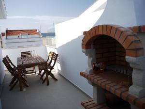 a balcony with a table and a brick oven at Bed & Seaside in Nazaré