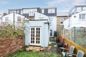 a small backyard with a brick fence and chairs at Cosy Victorian Terrace house in Jericho in Oxford