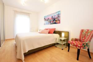 a bedroom with a large bed and a chair at Ferienwohnung Sommer - mit privatem Seezugang in Seeboden +33 photos