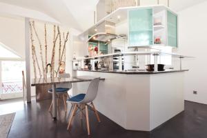 a kitchen with a counter and chairs and a table at Ferienwohnung Sommer - mit privatem Seezugang in Seeboden