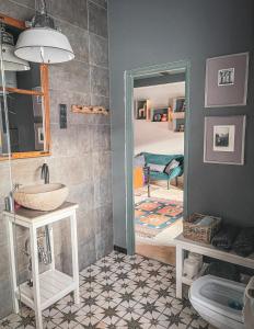 een badkamer met een wastafel en een spiegel en een slaapkamer bij Hungry Grape Guests in Erdőbénye
