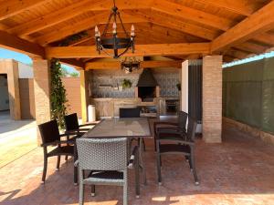 a patio with a table and chairs under a wooden ceiling at Casa de invitados con piscina privada y WIFI in Murcia