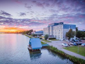 a boat with a blue roof sitting in the water at Hestia Hotel Haapsalu SPA in Haapsalu