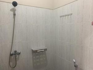 a shower with a shower head in a bathroom at RedDoorz near Alun Alun Purbalingga in Purbolinggo