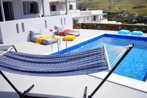 a hammock on the roof of a house with a swimming pool at Antigoni Villas in Gavrio