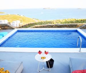 a table on a balcony with a view of the ocean at Antigoni Villas in Gavrio