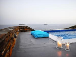 a table with two candles and a swimming pool at Antigoni Villas in Gavrio