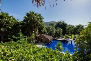 a swimming pool in a resort with palm trees at Layla Gocek Adults only in Göcek