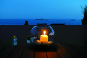 a candle in a glass vase on a table at Antigoni Villas in Gavrio
