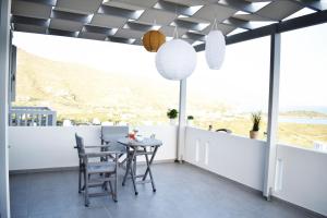 a dining room with a table and chairs on a balcony at Antigoni Villas in Gavrio
