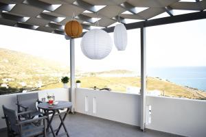 a balcony with a table and chairs and a view of the ocean at Antigoni Villas in Gavrio