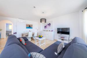 a living room with a blue couch and a tv at Brisa Marina in Colonia de Sant Pere