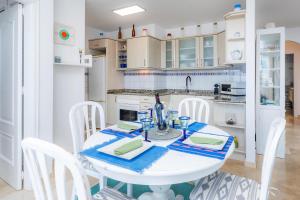 a white kitchen with a white table and chairs at Brisa Marina in Colonia de Sant Pere