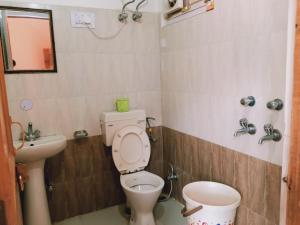 a bathroom with a toilet and a sink at Mahima in Sāngla