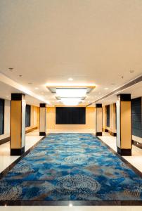 um quarto vazio com um grande tapete no chão em Jardin Hotels em Indore