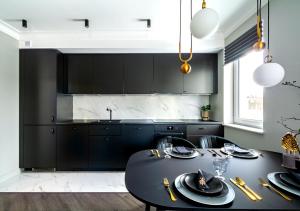 kuchnia z czarnymi szafkami i czarnym stołem w obiekcie Apartamenty Flat White Obywatelska 49 w Zielonej Górze