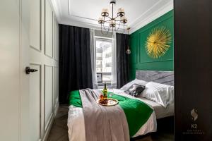 sypialnia z zielonymi ścianami i łóżkiem ze stołem w obiekcie Apartamenty Flat White Obywatelska 49 w Zielonej Górze