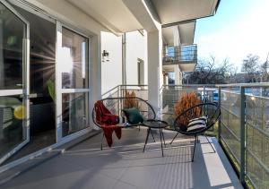 dwa krzesła i stół na balkonie w obiekcie Apartamenty Flat White Obywatelska 49 w Zielonej Górze