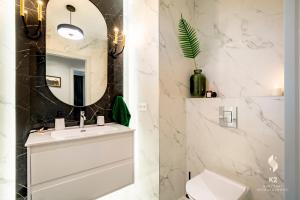 łazienka z białą umywalką i lustrem w obiekcie Apartamenty Flat White Obywatelska 49 w Zielonej Górze +28 zdjęć