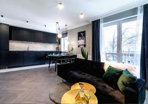 salon z czarną kanapą i kuchnią w obiekcie Apartamenty Flat White Obywatelska 49 w Zielonej Górze