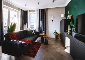 salon z czarną kanapą i telewizorem w obiekcie Apartamenty Flat White Obywatelska 49 w Zielonej Górze