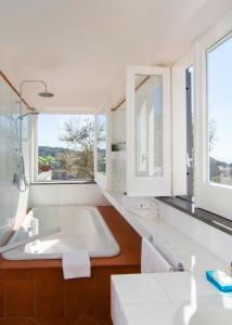 a bathroom with a tub and a sink and windows at Villa dei Golfi in SantʼAgata sui Due Golfi