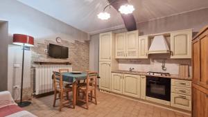 a kitchen with white cabinets and a table and chairs at Residenza dei Longobardi Affittacamere in Spoleto