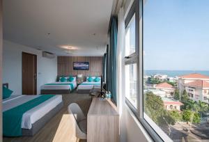 ein Hotelzimmer mit einem Bett und einem großen Fenster in der Unterkunft Delight Hotel in Quy Nhon