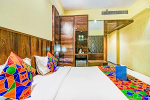 a bedroom with a large bed with colorful pillows at Hotel Crawford Inn in Mumbai