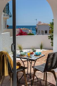 a table and chairs on a patio with a view of the ocean at Lemon Tree Apartment in Luz