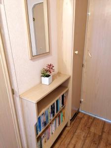 a book shelf with books in it next to a door at Poplar Lodge Log Caravan in Kirkby on Bain