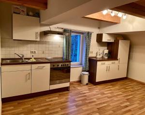 een keuken met witte apparatuur en een houten vloer bij Ferienwohnungen Weitblick & Am Speicher in Wiek auf Rügen 