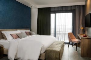 una camera d'albergo con un grande letto e una finestra di Coast Hotel & Spa - Adults Only a Milano Marittima