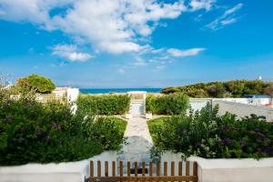 a garden with purple flowers and a fence at Artemida House in Artemida