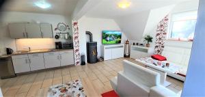 a kitchen and a living room with a tv in it at Fewo Traum in Neppermin