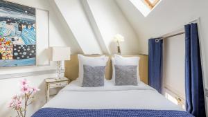 a bedroom with a bed with blue and white pillows at Luxury 2 Bedroom Duplex - Beautiful Monument View in Paris