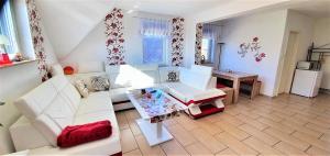 a living room with white furniture and a table at Fewo Traum in Neppermin
