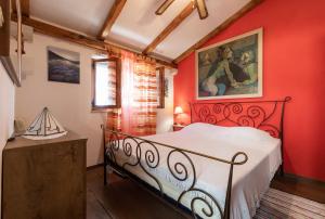 1 dormitorio con 1 cama con pared roja en Holiday Home Tania, en Vela Luka