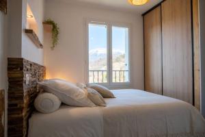 a bedroom with a large bed with a large window at CHARMAND T2 AVEC VUE SUR LAC, TERRASSE TOUT EQUIPE in Gap