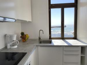 a kitchen with a sink and a window at Arinaga Colors, tu casa en la playa in Arinaga