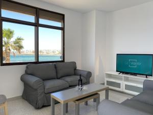 a living room with a couch and a tv at Arinaga Colors, tu casa en la playa in Arinaga