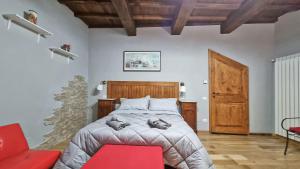 um quarto com uma cama e uma cadeira vermelha em Residenza dei Longobardi Affittacamere em Spoleto