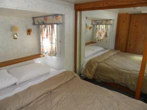 two beds in a room with two windows at Pahrump RV Park & Lodging in Pahrump