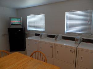 a kitchen with white cabinets and a table and a television at Pahrump RV Park & Lodging in Pahrump