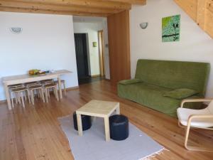 a living room with a green couch and a table at Casa de Sao Mamede in São Mamede