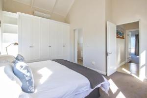 a bedroom with a large white bed in a room at Thesen Island Holiday House in Knysna