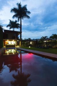 a house with a swimming pool with a palm tree at Humura Resorts in Kampala