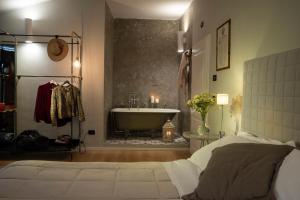 a bedroom with a bath tub and a bed and a sink at Il Battistero Siena Residenza d'Epoca in Siena