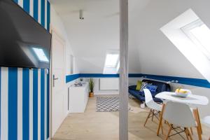 a living room with a blue and white striped wall at Apartamenty Pomona in Niechorze